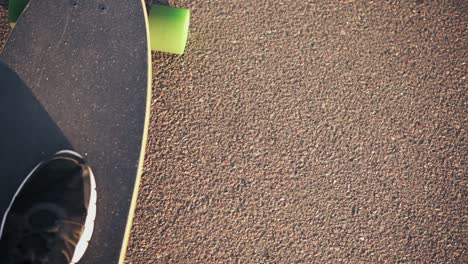 Closeup-View-Of-A-Leg-In-Black-Sneakers-Skateboarding-On-The-Road-In-The-City