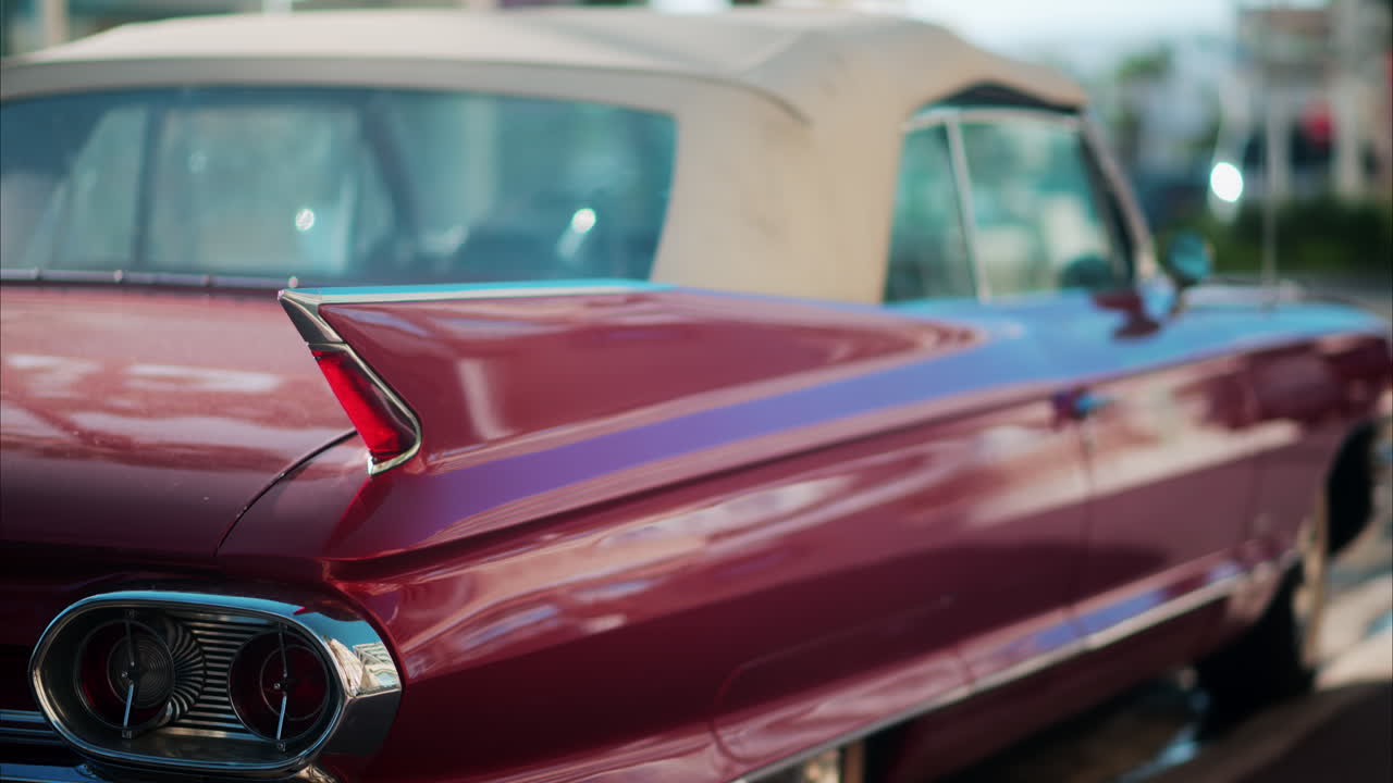 Close up of the side of a burgundy, retro car parked on the street