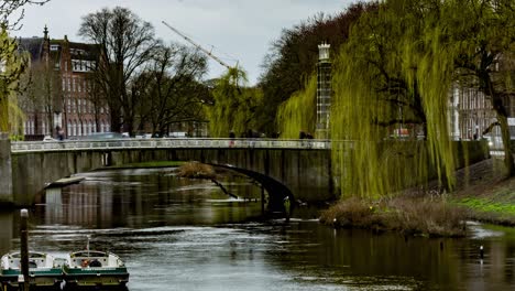 time lapse of people and cars crossing bridge over river in den bosch, the netherlands - wide pan