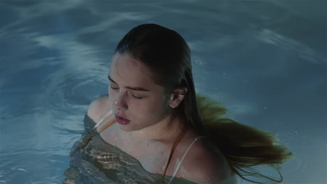 a girl with red hair in slow motion emerged from the water