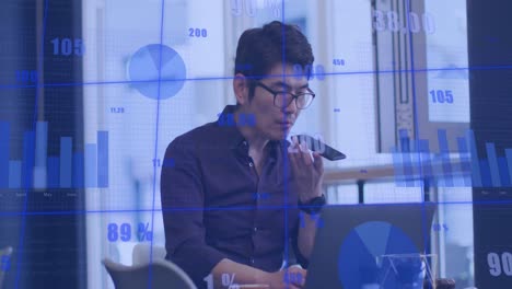 Animation-Der-Statistischen-Datenverarbeitung-Gegen-Einen-Asiatischen-Mann,-Der-Im-Büro-Auf-Dem-Smartphone-Spricht
