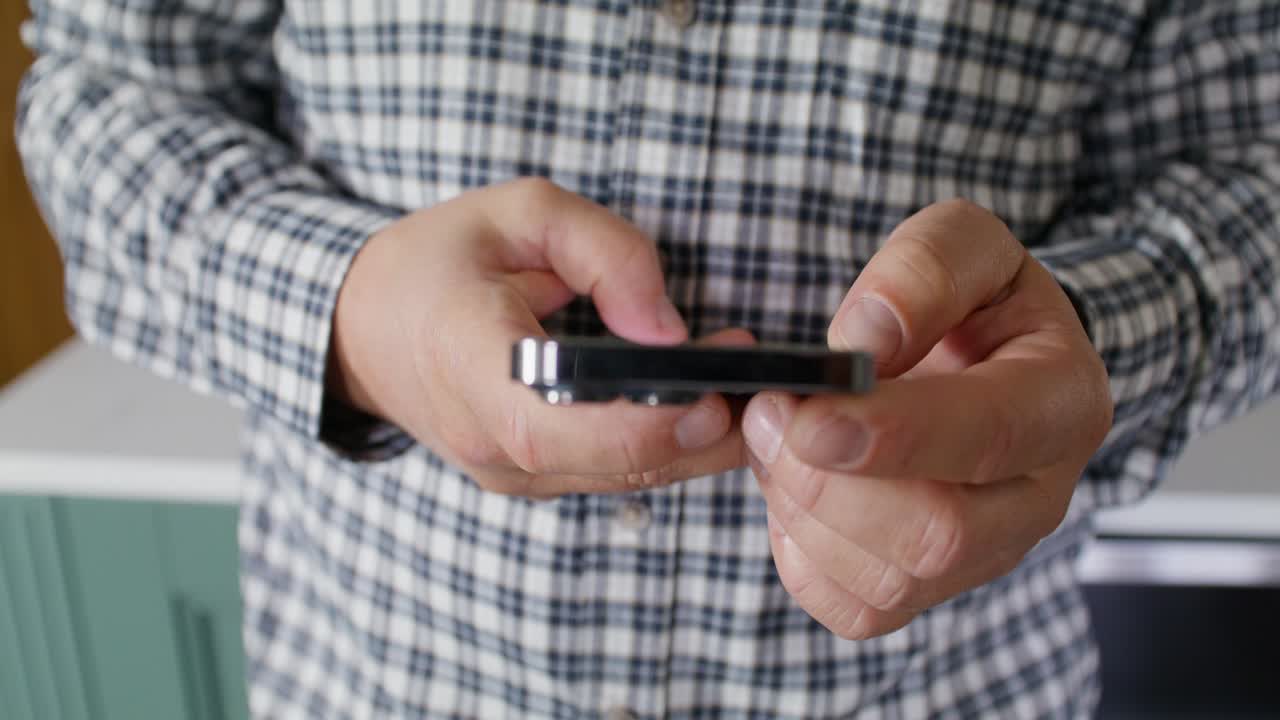 Person Holding Smartphone in a Kitchen