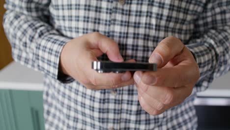 persona con un teléfono inteligente en una cocina