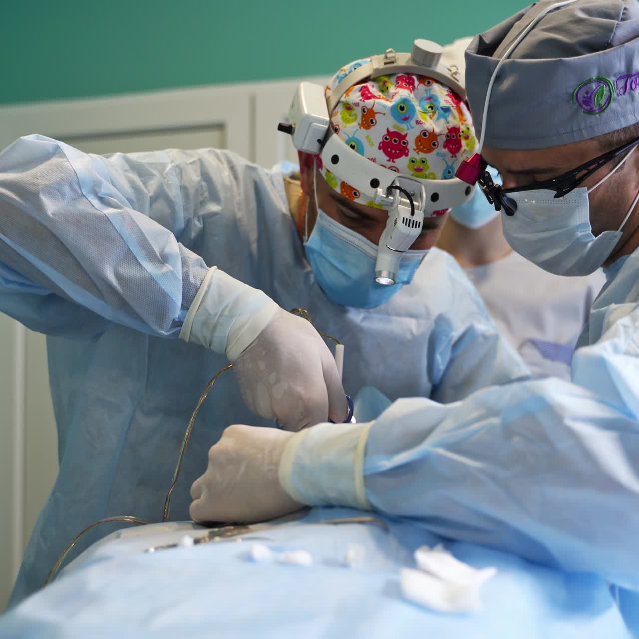 Surgeon team cooperating during operation. Surgeon in funny hat uses electric device tools and changes them quickly