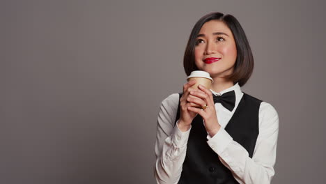 asian receptionist serving coffee cup in front of camera