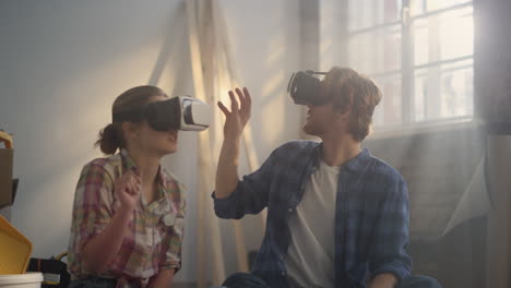 happy family sitting in vr glasses on floor. couple making redesign indoors.