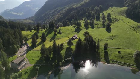 sun reflection on a beautiful lake in summer swiss in a scenic drone shot on wooden cottage in a small rural area town nafels obersee switzeland travel in summer season to wonderful nature landscape