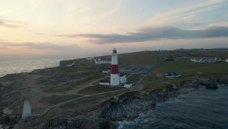 drone moves around the portland bill's lighthouse on a beautiful summer sunset, in dorset, england