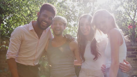 retrato de amigos homosexuales masculinos y femeninos en casa en el jardín contra el sol ardiente juntos