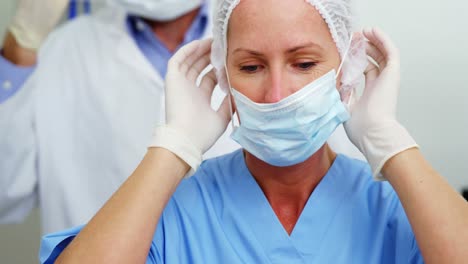 dentista y asistente dental con máscara quirúrgica