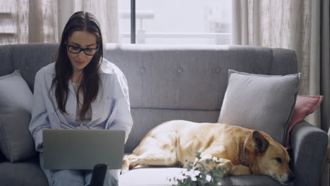 mujer escribiendo en la computadora portátil a su lado mientras trabaja