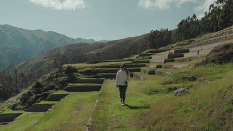 woman walking through ancient agricultural terraces in the mountains