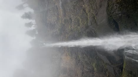 el agua de una cascada cayendo en un día de niebla