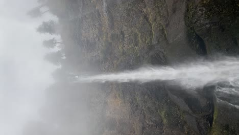 the water of a waterfall falling in a foggy day