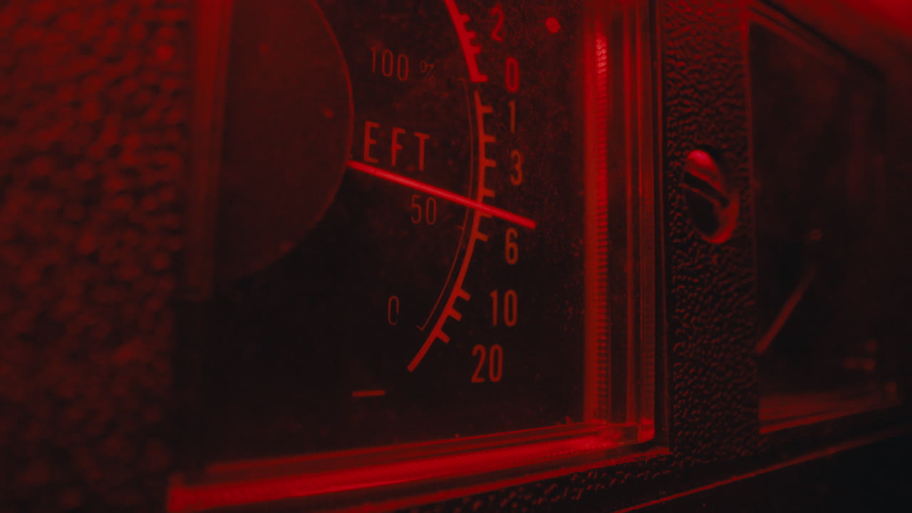 A close-up on a vintage tape recorder in a red blinking light
