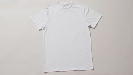 video of flat lay of white t shirt with copy space on white background