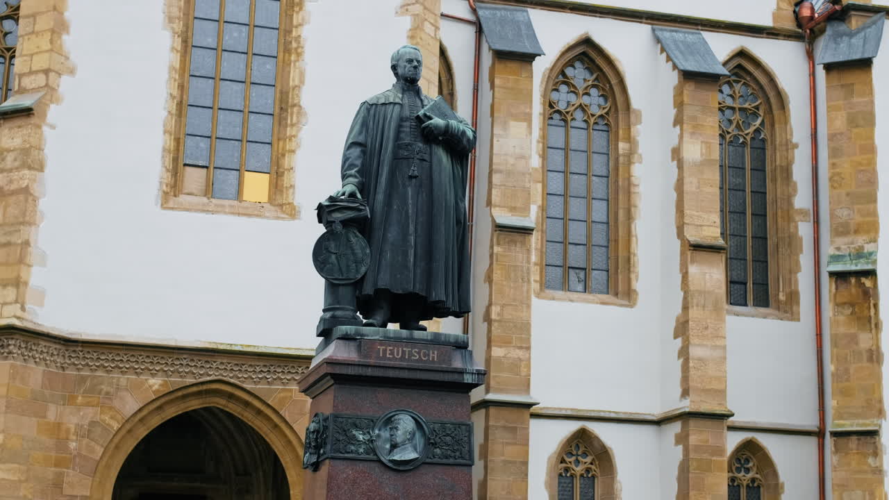 Statue of Bishop Georg Daniel Teutsch in Sibiu, Romania. Sibiu Lutheran Cathedral on the background