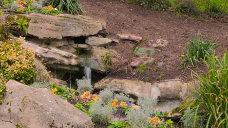 Small-Stream-Water-Running-Over-Rocks-In-Jardin-des-plantes-d'Angers-Park-In-France---close-up