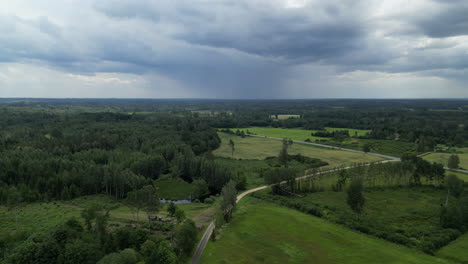 Time-lapse-rural-grass-field-and-forest,-sky-covered-with-clouds-moving