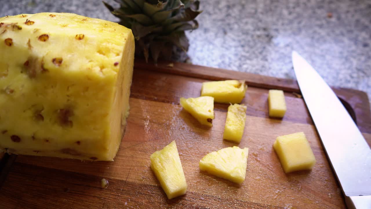 칼로 나무 판자에 다진 파인애플 과일