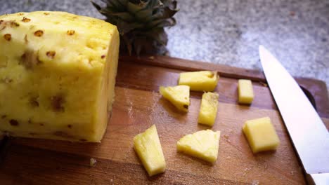 fruta de piña picada en tablero de madera con cuchillo