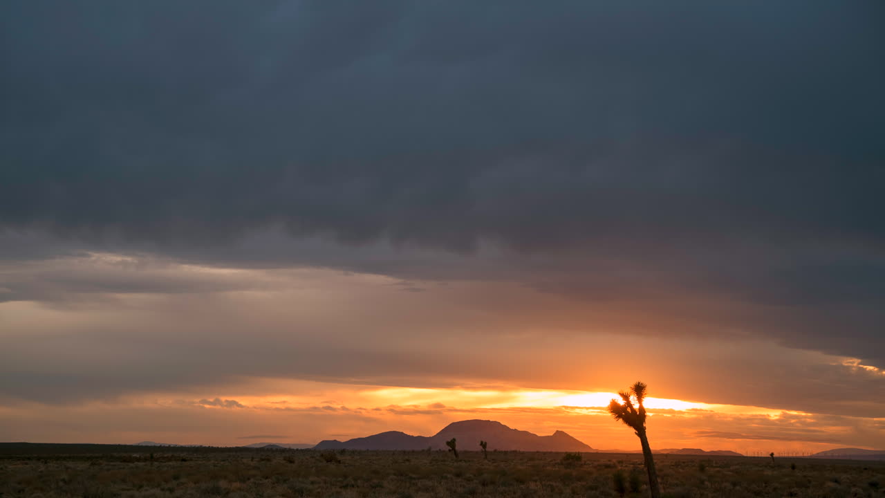 majestuosa puesta de sol sobre el desierto de mojave con juego dinámico de nubes y siluetas, time-lapse
