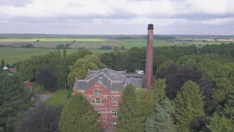 4k drone footage panning in towards an old brick building in the middle of a forrest