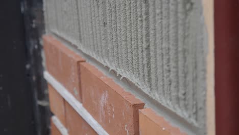 close-up of a bricklayer laying bricks on a wall