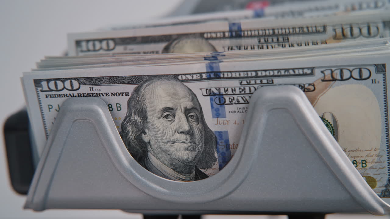 Modern automatic machine counting dollar bills denomination of hundred closeup