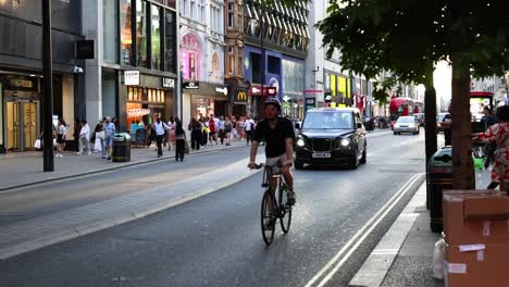 cyclist navigating through busy london shopping street