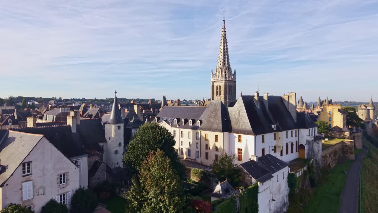 Church of Notre Dame of Vitre steeple rises above town rooftops under soft bright morning light