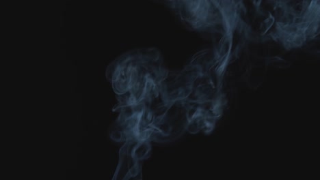 white smoke rises up to the air, black background