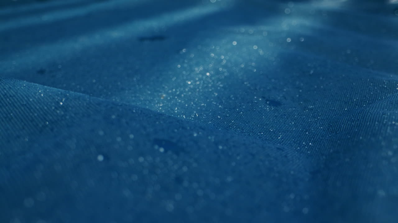 A serene water surface with gentle ripples and glistening raindrops in calming blue hues, creating peace