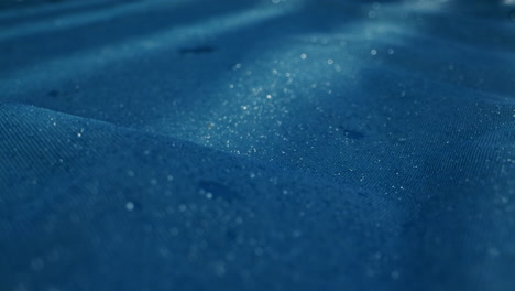 a serene water surface with gentle ripples and glistening raindrops in calming blue hues, creating peace