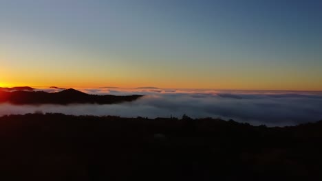 Un-Hermoso-Amanecer-Sobre-Las-Colinas.-Las-Nubes-Bajas-En-El-Valle,-A-Medida-Que-El-Hijo-Se-Eleva-Crean-Una-Hermosa-Imagen,-El-Hijo-Abriéndose-Paso