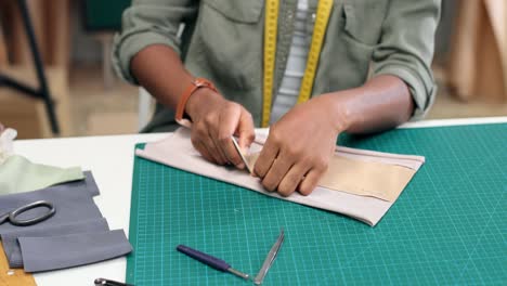 Close-Up-View-Of-Woman-Tailor-Sitting-On-Table-Drawing-Lines-On-Clothing-Sketch-In-Sewing-Workshop