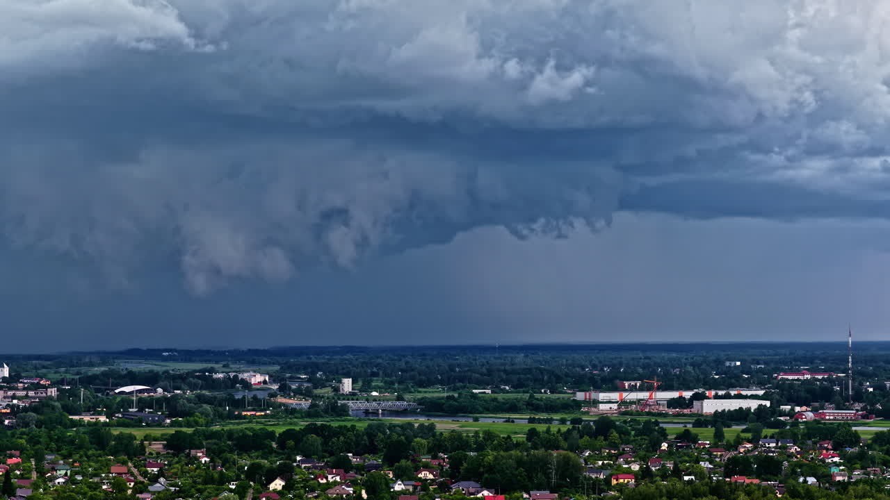 Storm clouds rolling over fields and rural countryside in moody natural light, climate change natural disaster