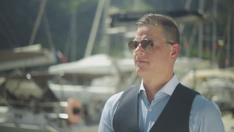 man in sunglasses by boats at the marina