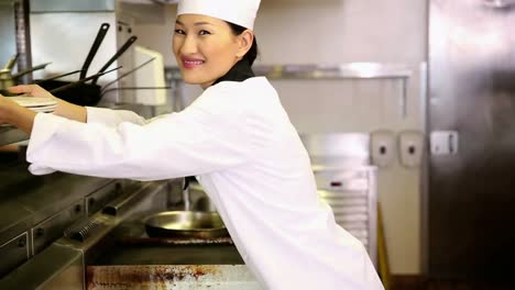 asian chef putting away stack of plates