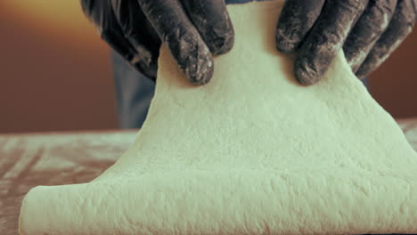 preparing dough with gloved hands