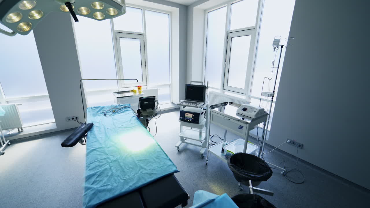 Light spacious white surgical room with minimum equipment. Footage around the operational table in the centre of empty ward.