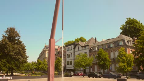 Agua-Que-Cae-De-Una-Fuente-única-En-La-Zona-Pavimentada-De-La-Plaza-Jamblinne-De-Meux-En-Schaerbeek,-Bruselas,-Bélgica