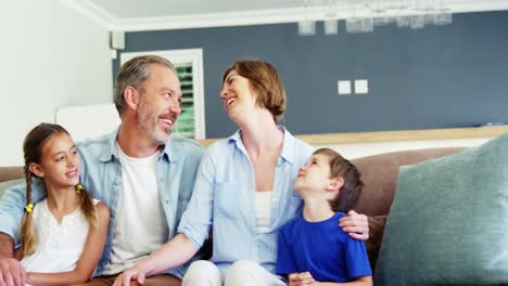 Glückliche-Familie-Sitzt-Auf-Dem-Sofa-Im-Wohnzimmer