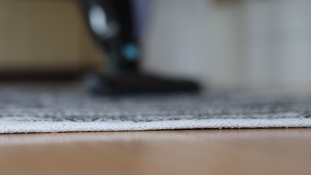 mujer irreconocible limpiando el piso de madera en la sala de estar