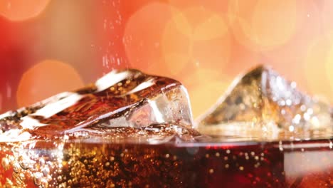 glass of cola. ice cola with splashing bubbles slow motion on a blurry light ,blurry background.