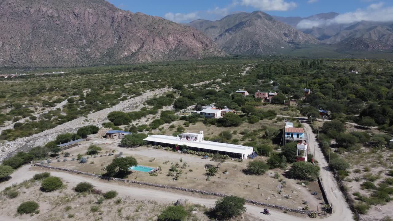 Aerial view of a remote valley with scattered buildings and mountains