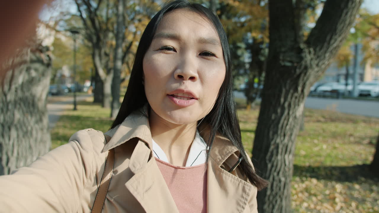 가을 공원에서 셀피를 찍는 여자