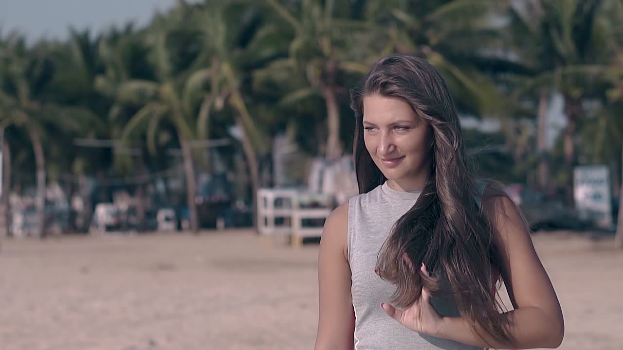 회색 의 예쁜 여자 가  ⁇ 빛 이 있는 바다 해안 에 서서히 포즈 를 취 하고 있다