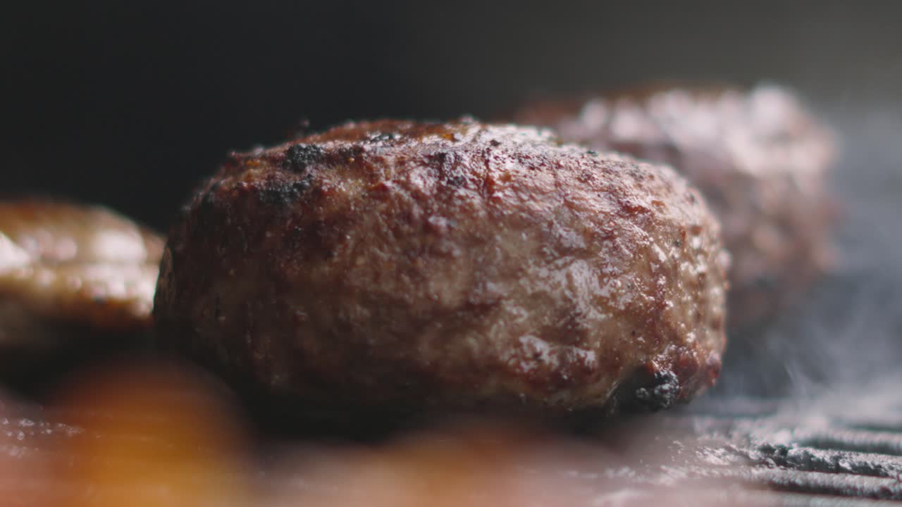 Static Shot of Thick Large Beef Burger Patty Cooking on Hot Iron Grill. Well Done Quarter Pounder Meat Cooked Outside. Processed Minced Ground Beef