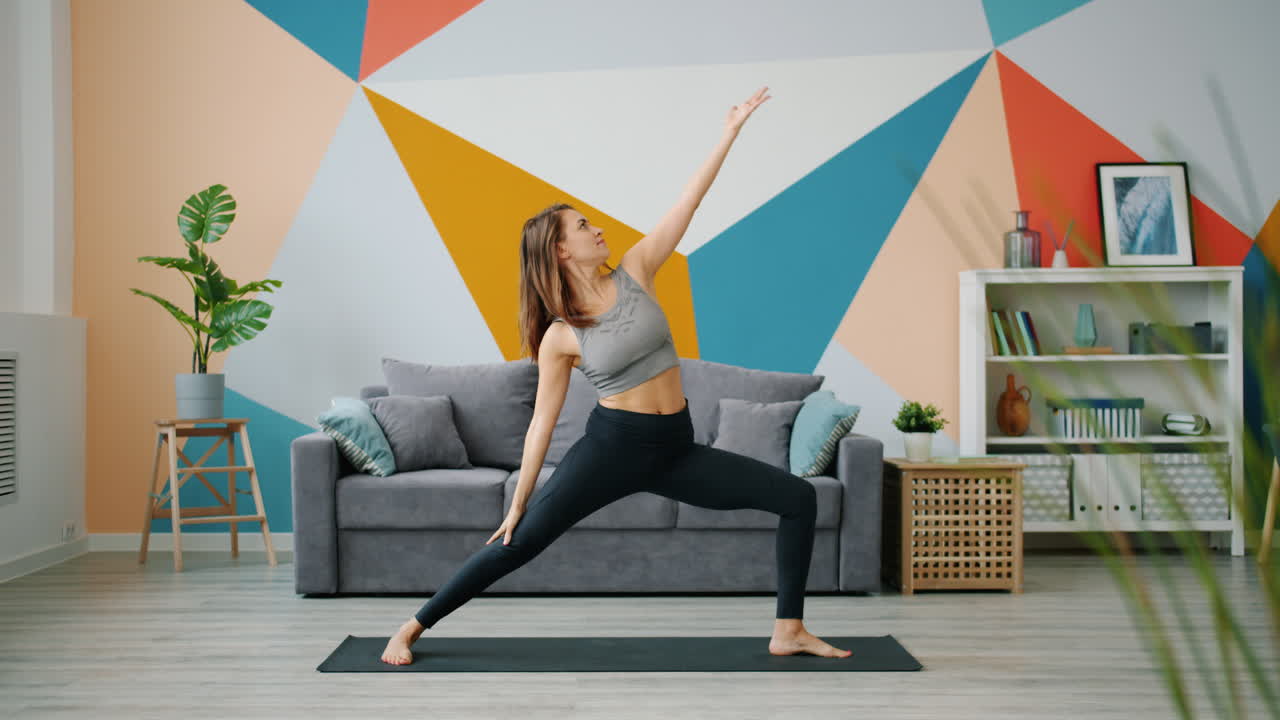 mujer practicando posturas de yoga en casa
